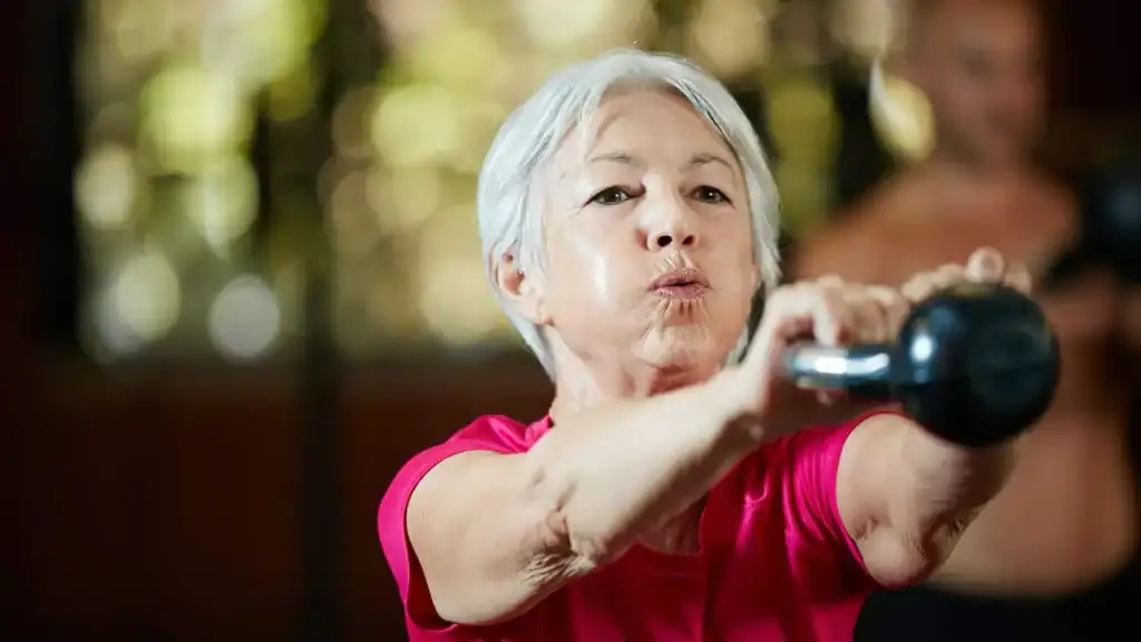 Toning Arms After 60: Empowering Womens Fitness Through Effective Weight Training 1 Older woman doing weight training Stourbridge to help her strength and longevity