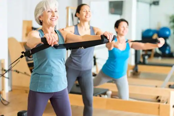 Toning Arms After 60: Empowering Womens Fitness Through Effective Weight Training 2 older woman doing weight training Stourbridge and resistance in the gym to tone upper arms