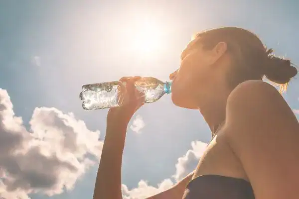 Hydration: The Secret Ingredient for a Toned Stomach and Enhanced Fitness 3 Image of woman drinking water to hydrate Stourbridge after run.
