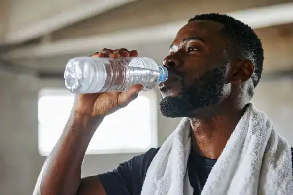 Hydration: The Secret Ingredient for a Toned Stomach and Enhanced Fitness 1 Image of man drinking water to improve hydration Stourbridge after work out.